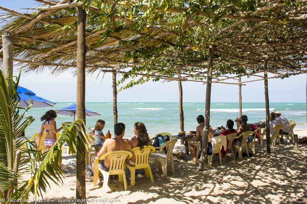 Imagem de famílias no quiosque na bela Praia da Boca da Barra.